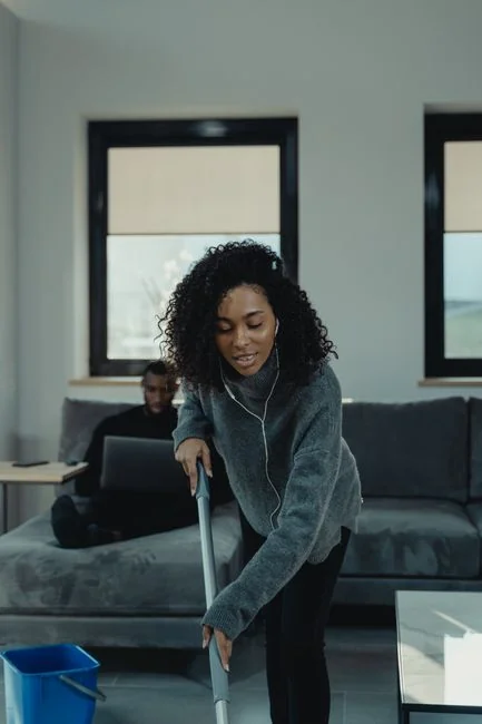 about-us-02 Woman wrapping a sofa with plastic for moving in a bright living room.